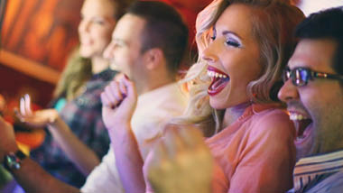 People cheering at slot machine
