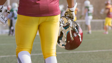 football player walking off field with helmet